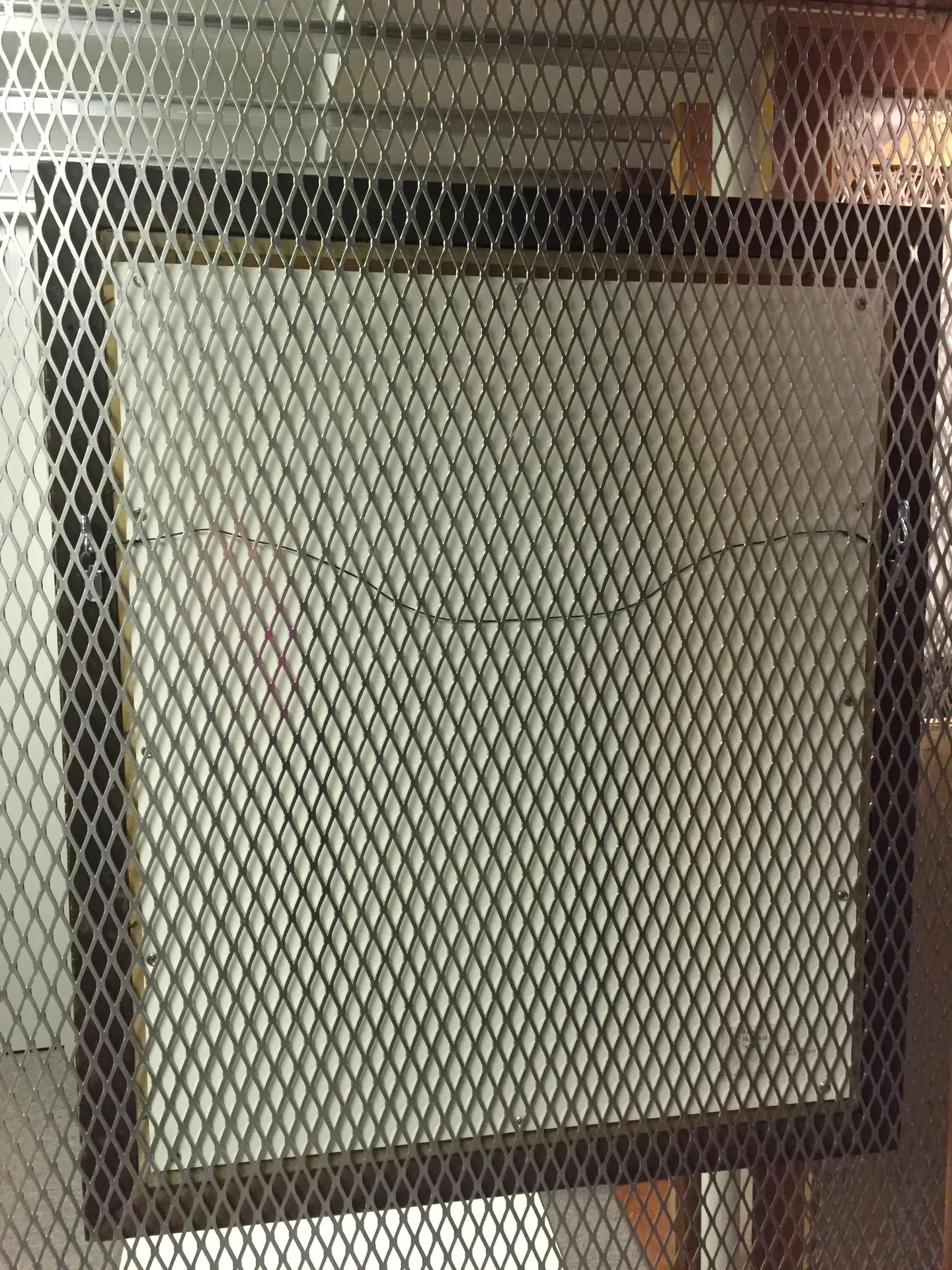 Alice Snell's portrait locked behind a metal security cage in the Florence Griswold Museum storage room